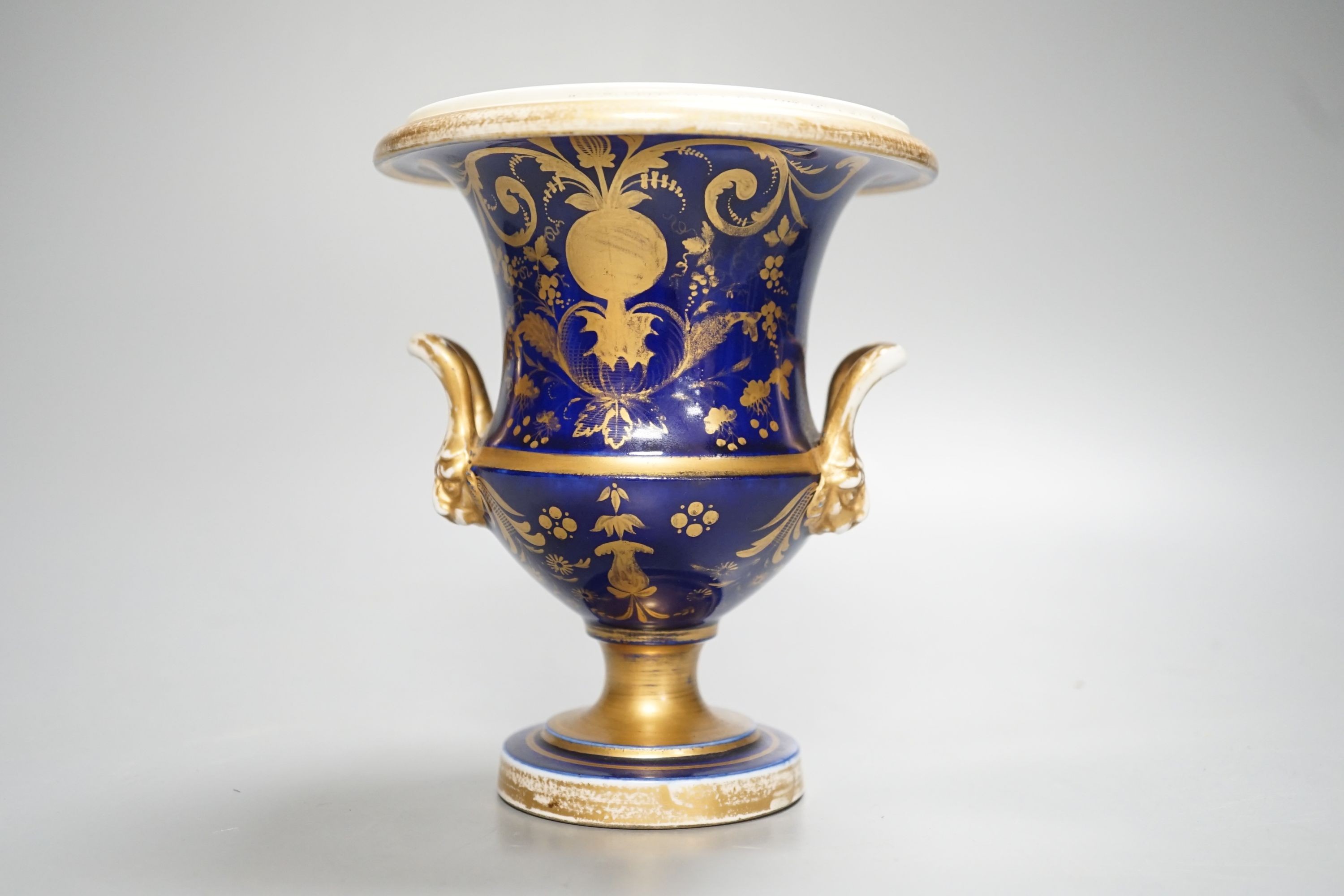 A Herculaneum two handled pedestal campana shaped vase, painted with basket of flowers, within a shaped cartouche on a cobalt blue and gilt ground, c.1815, height 14.5cm
